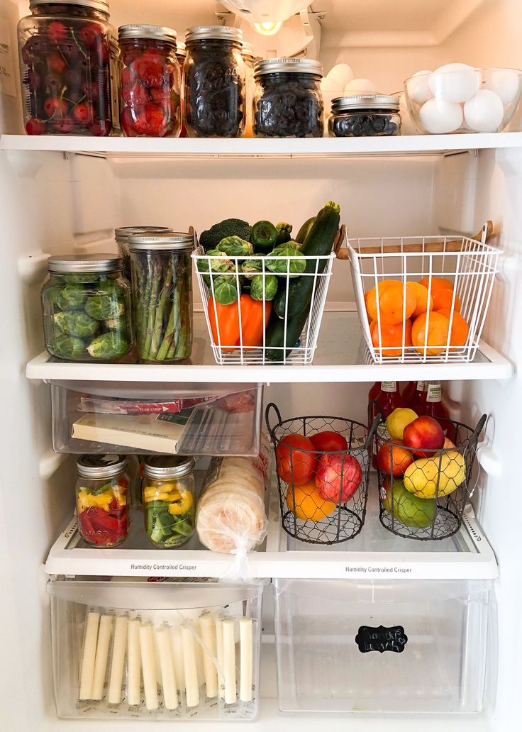 an open refrigerator filled with lots of different types of vegetables and fruit in containers on the shelves