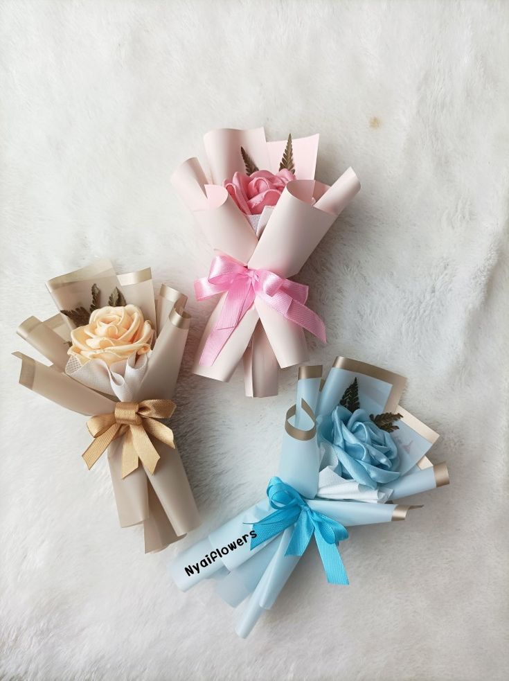 four different types of paper flowers on a white surface