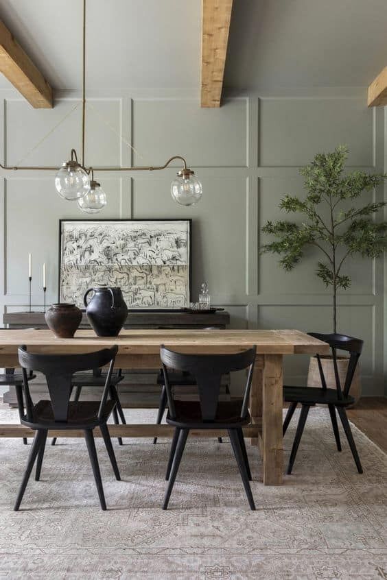 a dining room table with chairs and a vase on it