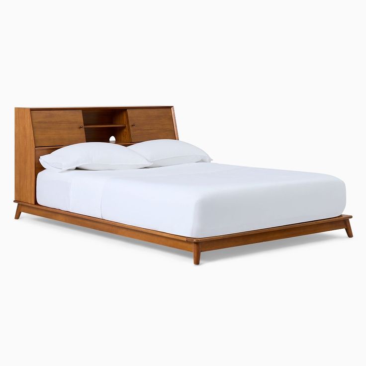 a bed with white sheets and wooden headboard on top of it's frame