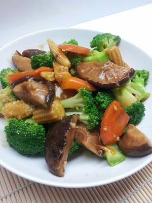 chicken and broccoli stir fry with sauce on a white plate, ready to be eaten