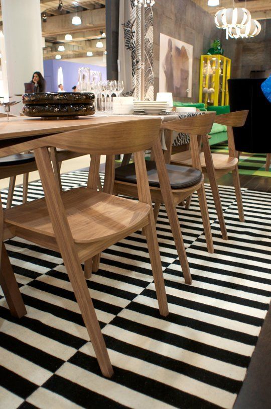 a dining room table and chairs with black and white checkered flooring in front of it