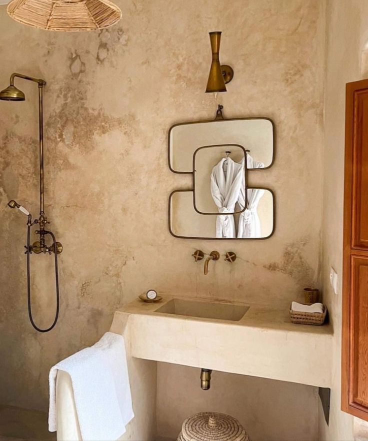 a bathroom with a sink, mirror and shower in it's center wall next to a towel rack