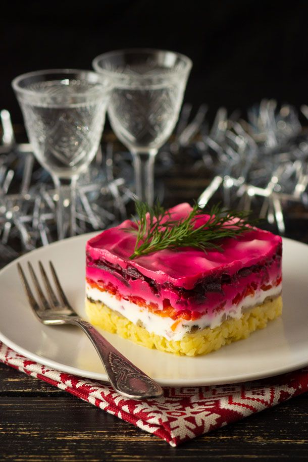 a piece of cake sitting on top of a white plate next to two wine glasses