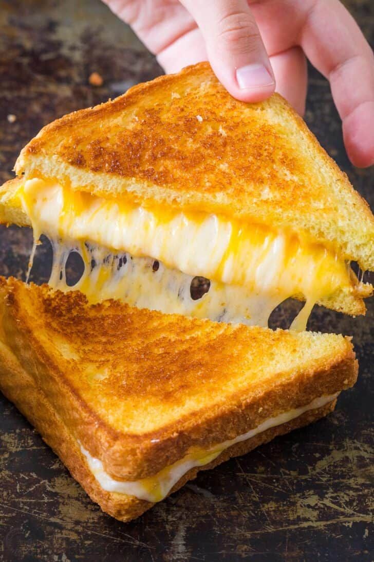 a grilled cheese sandwich is being held by someone