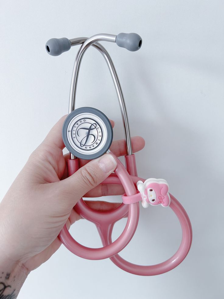 a hand holding a pink stethoscope with an elephant on it