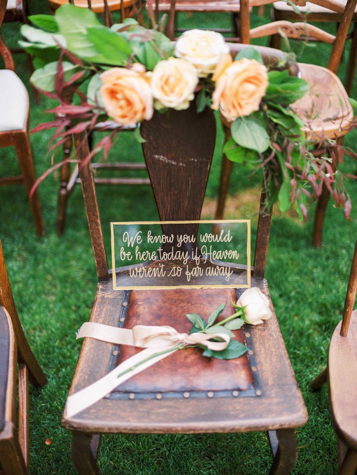 a wooden chair with a sign and flowers on it