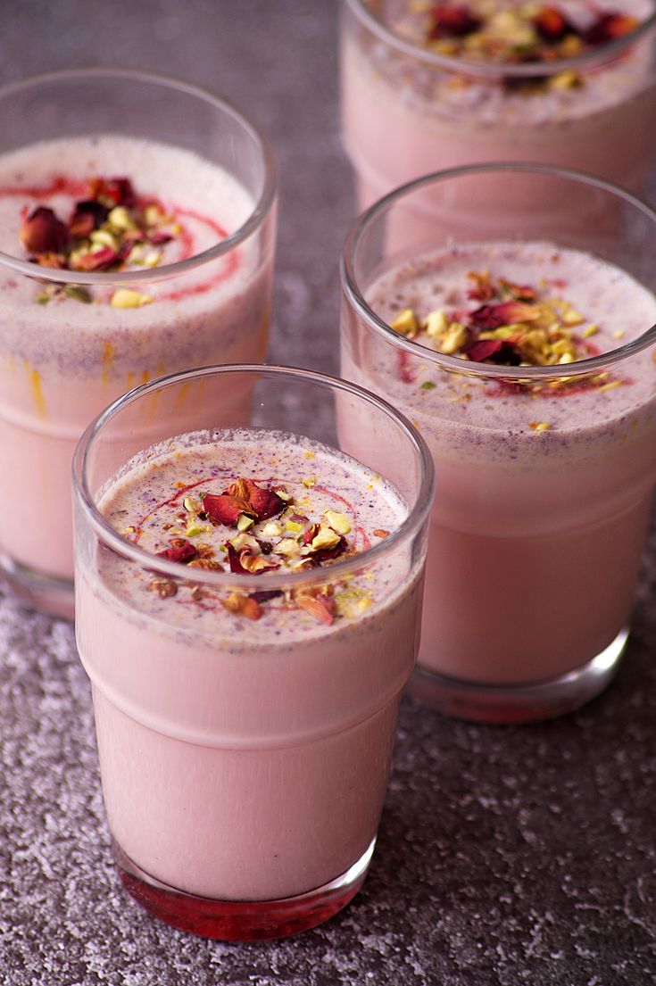 three glasses filled with dessert sitting on top of a table