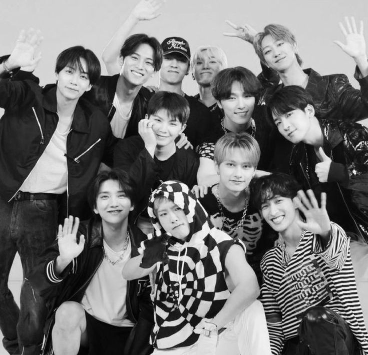 black and white photo of group of young men posing for the camera with their hands in the air