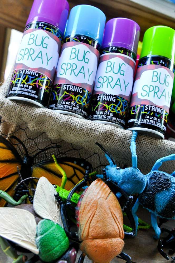 bug sprays are sitting on the table next to some bugs and other insect toys