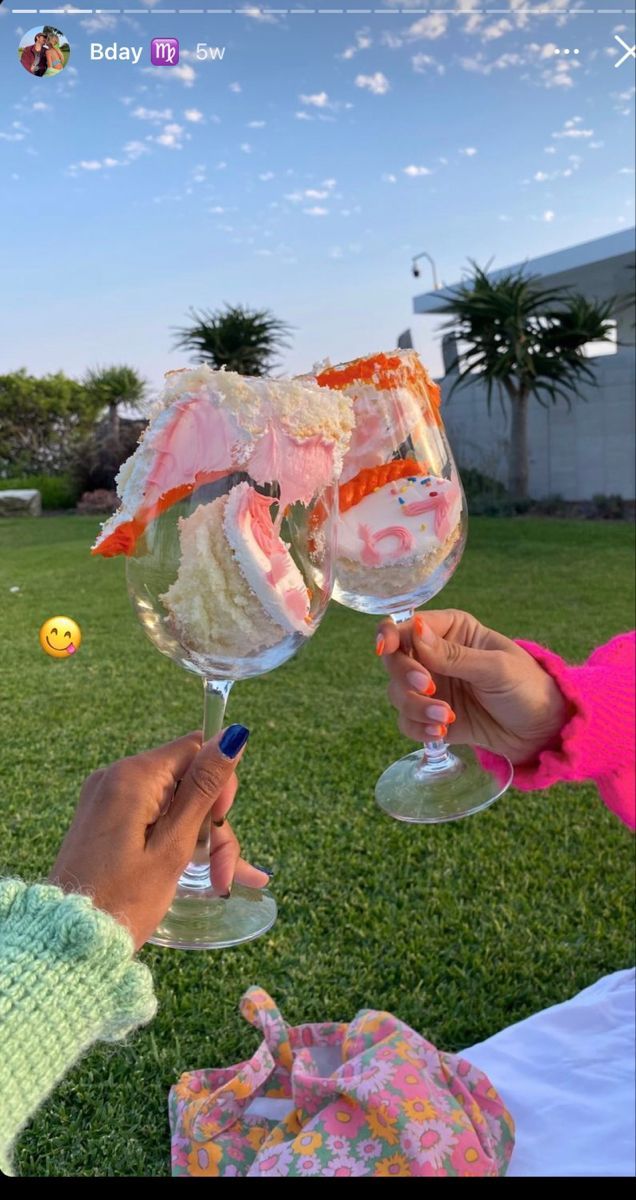 two people toasting wine glasses in the grass