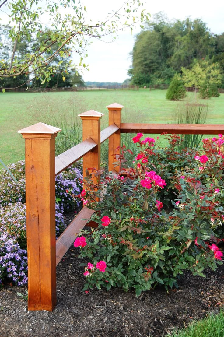 a wooden fence surrounded by flowers and shrubs