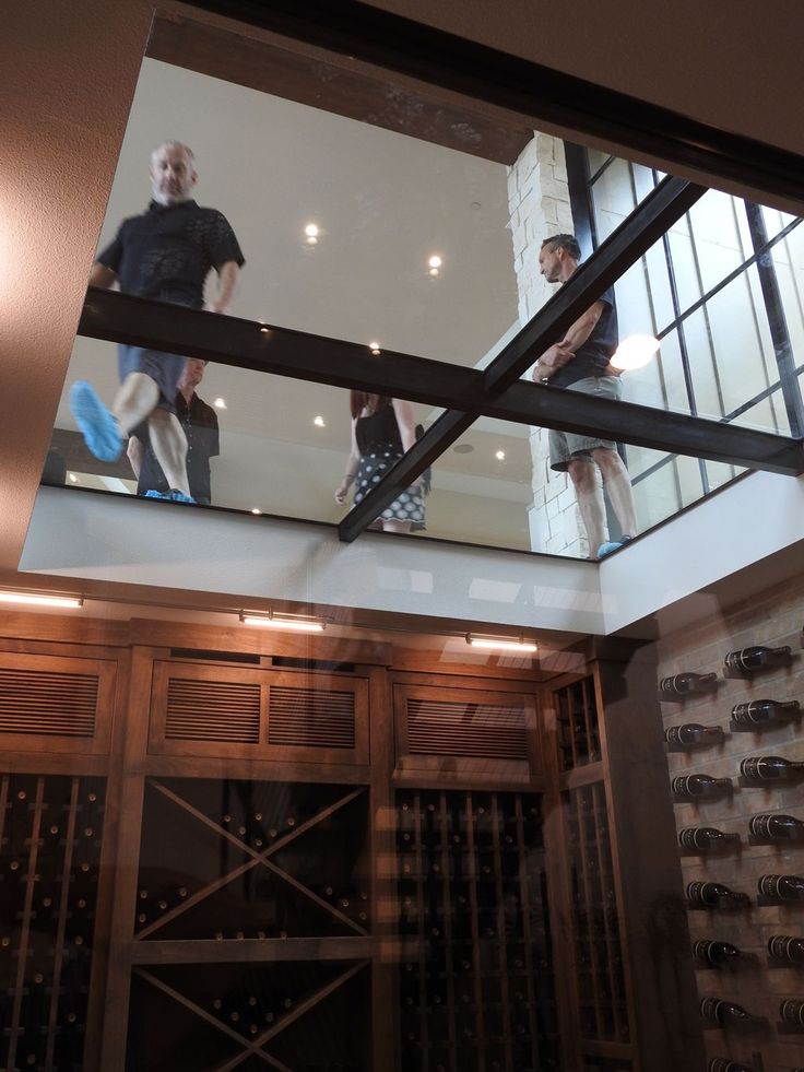 two people standing on top of a wine rack