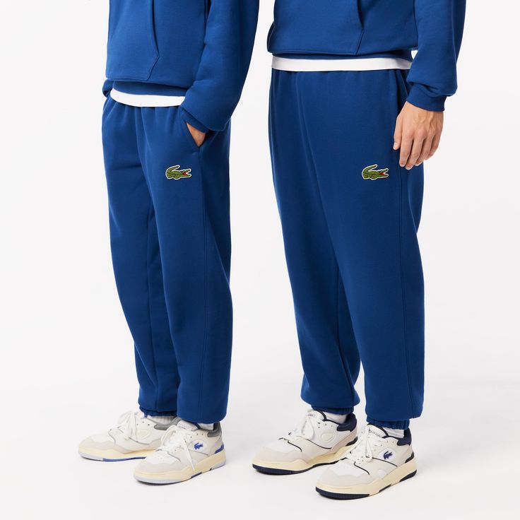 A lesson in French chic on the move: these Lacoste sweat pants are made from a warm, thick, super-soft fleece fabric. Inspired by training kits, with stylish streetwear-inspired touches. An adjustable, practical, contemporary piece. Sweat Resistant Athleisure Bottoms For Streetwear, Casual Sports Tracksuit With Pockets, Sporty Fleece Tracksuit With Pockets, Casual Fleece Joggers For Sports Season, Casual Fleece Sweats For Sports, Sporty Stretch Fleece Tracksuit, Blue Athleisure Pants With Ribbed Cuffs, Casual Winter Tracksuit With Moisture-wicking, Fleece Joggers For Leisure