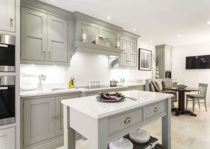 a kitchen with gray cabinets and white counter tops