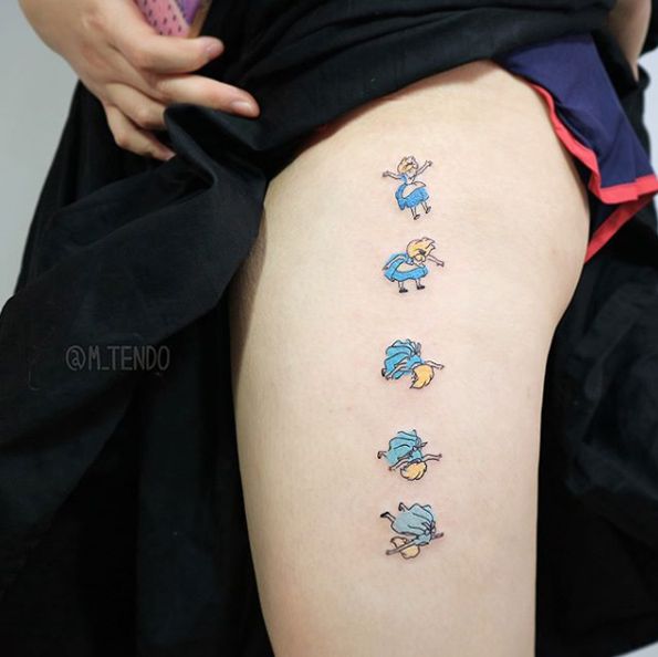 a woman's thigh with some cartoon tattoos on it