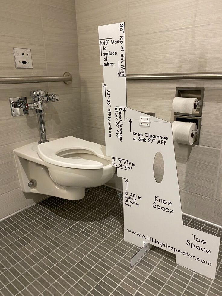 a white toilet sitting in a bathroom next to a sign