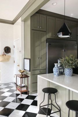 a black and white checkered floor in a kitchen with two stools next to the counter