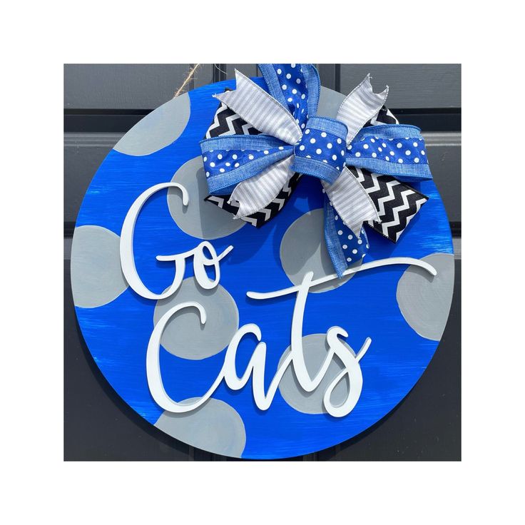 a blue and white sign that says go cats with a bow on it's front door