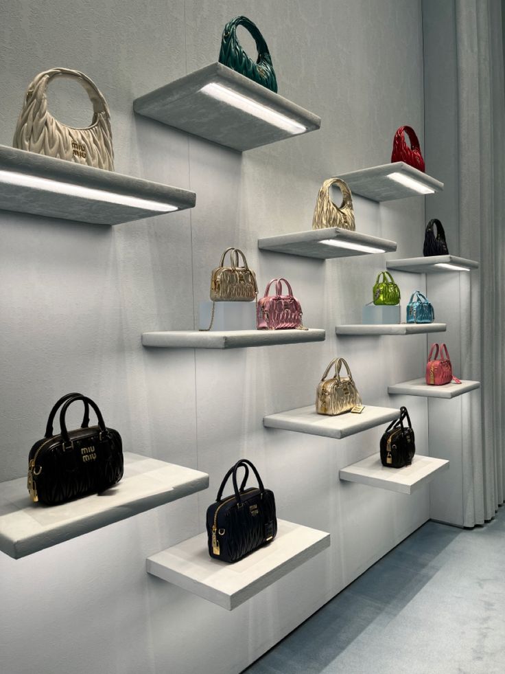 several shelves with purses and handbags on them, all lined up against the wall