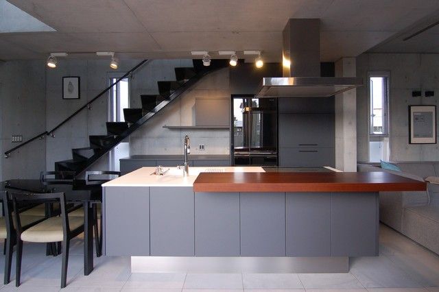 a kitchen with an island and stairs in the background