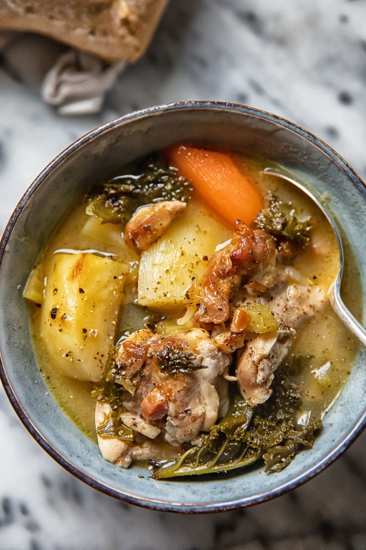 a close up of a bowl of food with meat and vegetables in it on a table