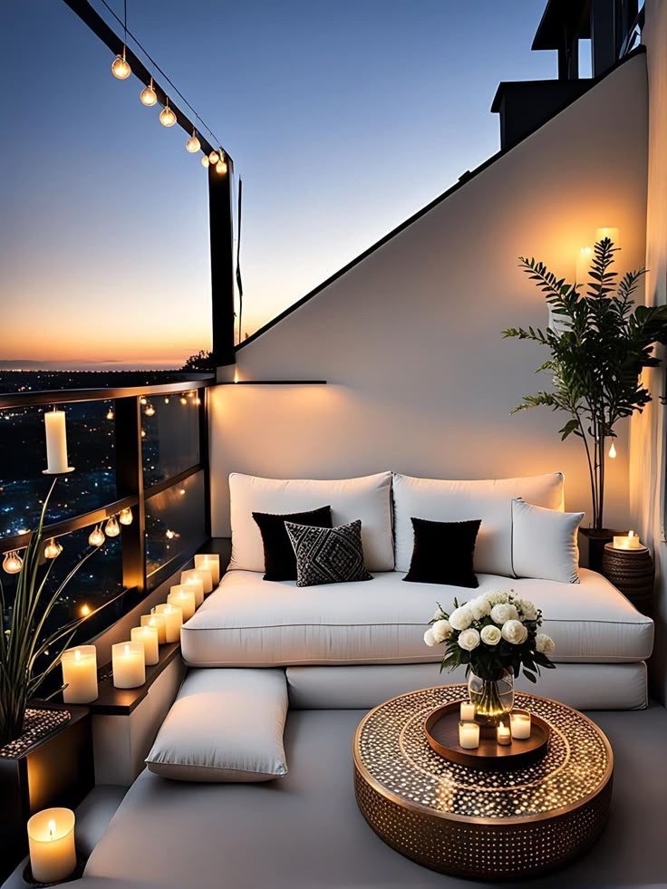 a white couch sitting on top of a wooden floor next to a table with candles