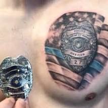 a man's chest with an american flag and police badge tattoo on his chest