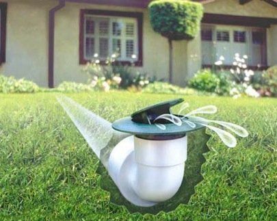 a sprinkler is spraying water on the grass in front of a house