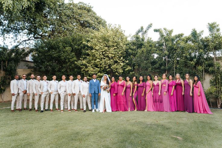 a group of people standing next to each other on top of a lush green field