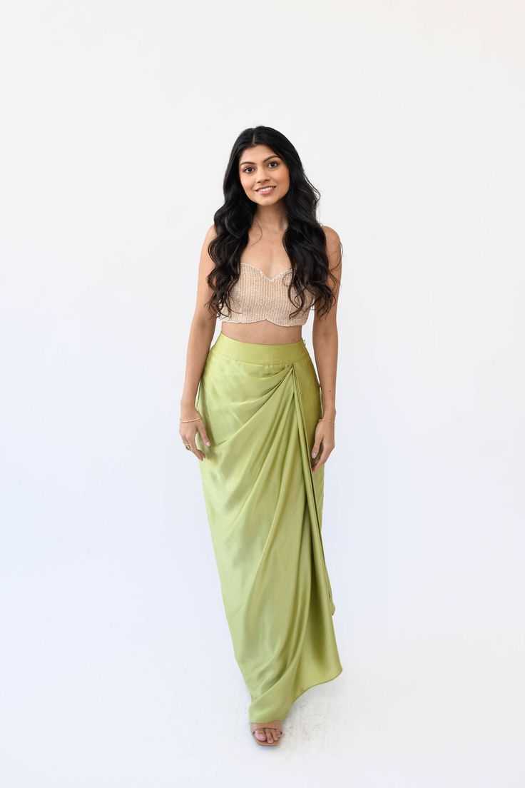 Experience the understated elegance of our Satin Drape Skirt. Crafted with a fitted waistband for a seamless silhouette fit and finished with a timeless drape, this piece is crafted from a luxuriously soft silk satin fabric, perfect for a flowy, feminine look. Features: Zipper and hook closure Fitted waistband Included in purchase: Pista Drape Skirt Side Drape Skirt, Satin Dhoti Skirt, Satin Skirt Design, Saree Skirt Drape, Satin Draped Skirt, Dhoti Style Skirt, Satin Clothes Outfit, Draping Skirt Design, Satin Indian Outfit