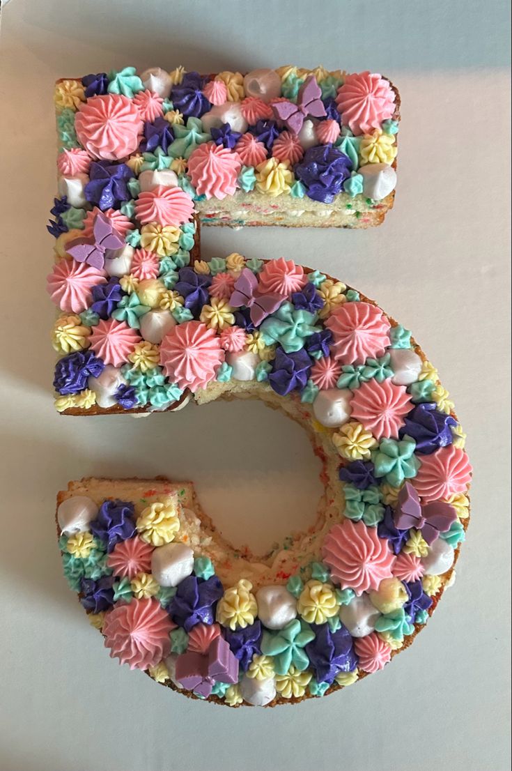 the letter e is made up of colorful flowers and icing on top of cake