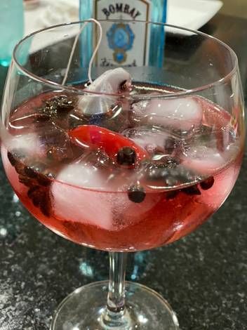 a wine glass filled with ice and berries