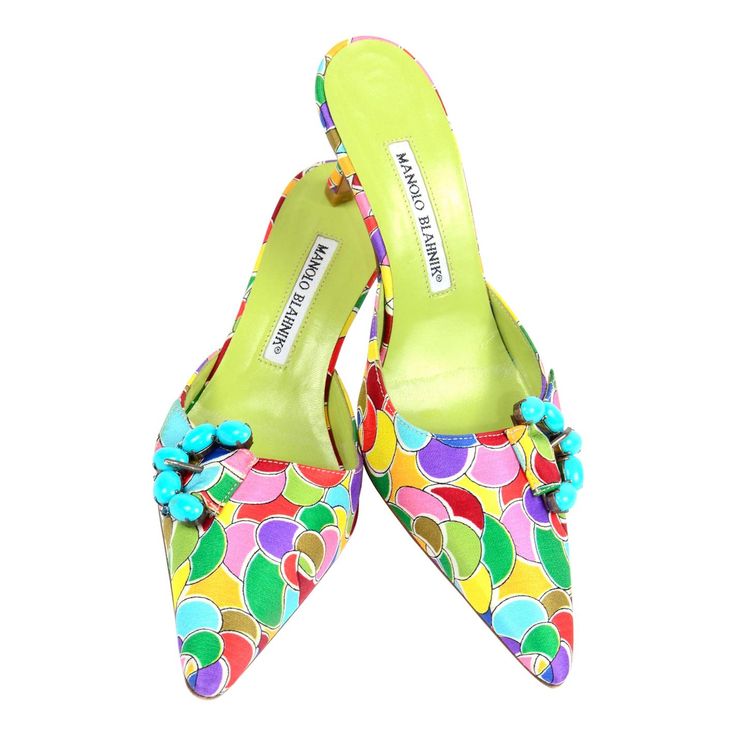 These are such fun, brightly colored Manolo Blahnik heeled mules with turquoise and rhinestone buckles. These fabulou shoes have a colorful printed pattern in shades of blue, red, light blue, purple, tangerine, yellow, green, olive, and white. The soles are leather and the shoes come in original box with their original dust bag. The style name is Atomica in the color turquoise. Made in Italy and labeled size 36 1/2. Please keep in mind that Manolo Blahnik shoes run a half size small. So please o 1stdibs Fashion, Manolo Blahnik Mules, Heels Green, Ossie Clark, Bianca Jagger, Manolo Blahnik Black, Manolo Blahnik Heels, Cecil Beaton, Diana Vreeland