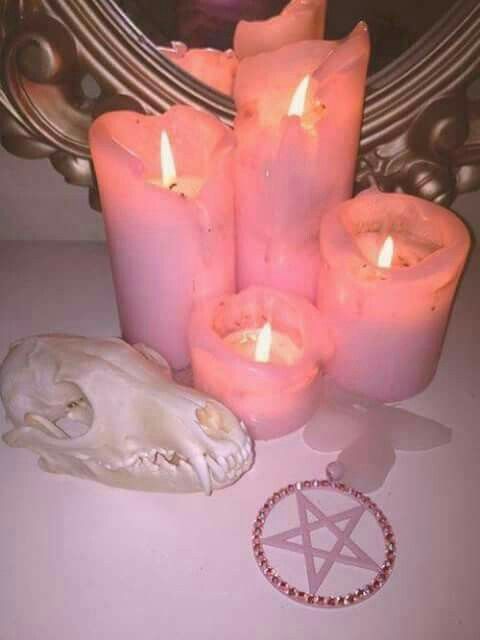 some candles are sitting on a table next to a skull