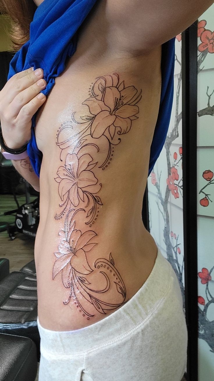 Complete side piece (outline)  13" long along ribs, waist, & hip. Will be shaded & colored 💙💜💗 Ink courtesy of Wesley @ Street Monkey Tattoo in Sheboygan, WI Cool Side Tattoos For Women, Lily Outline Tattoo, Side Rib Cage Tattoos For Women, Lilly Hip Tattoo, Water Lily Back Tattoo, Lily Hip Tattoo, Lily Tattoo Design On Ribs, Side Tattoo Women, Lily Stomach Tattoo