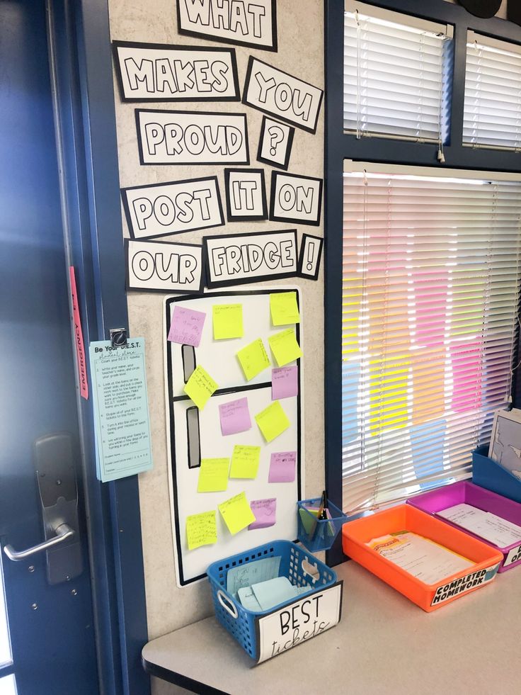 a bulletin board with post it notes on it and some bins in front of it