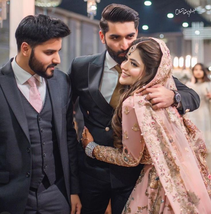 two men and a woman standing next to each other at a wedding ceremony in india