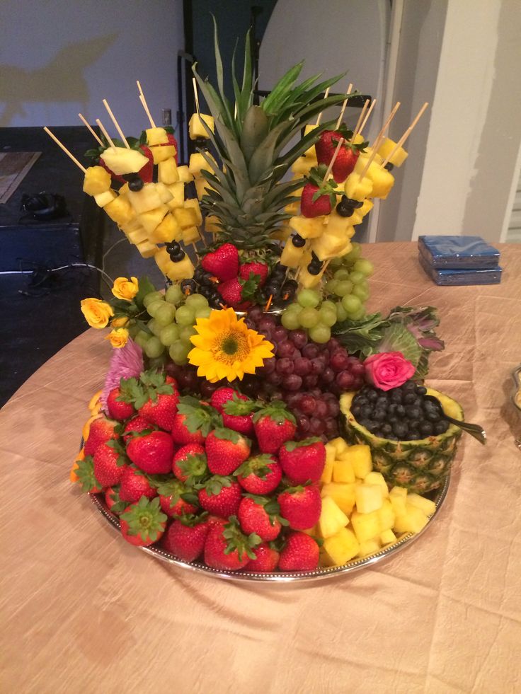 a platter filled with lots of fruit on top of a table