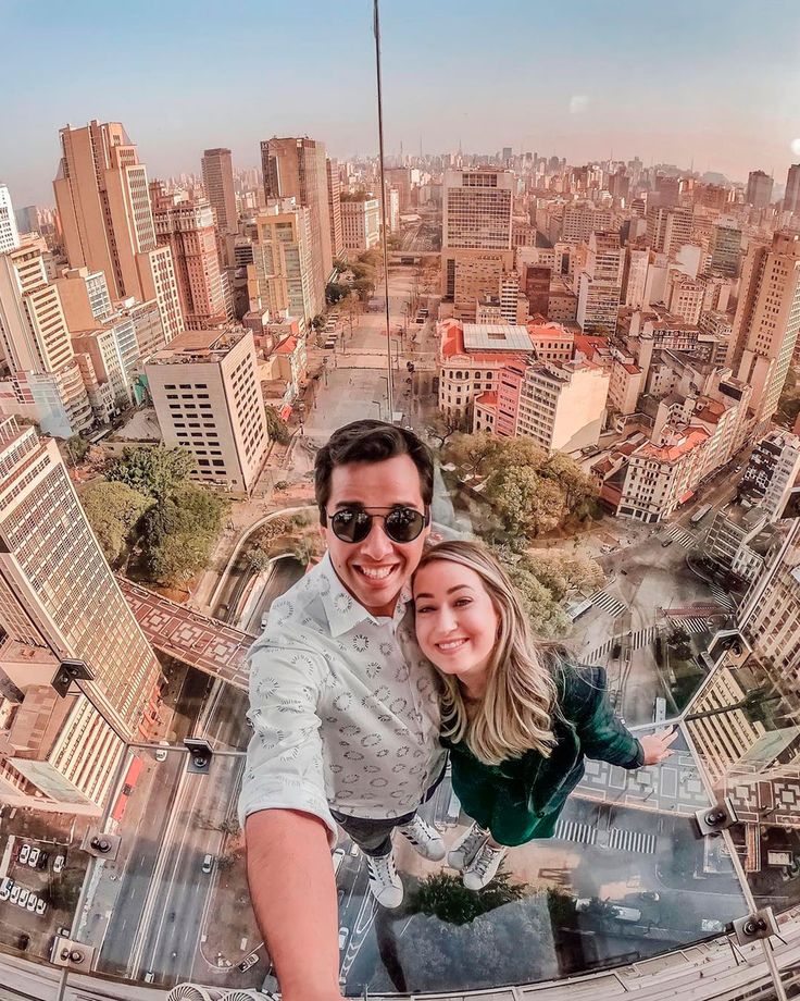 a man and woman taking a selfie in the middle of a cityscape