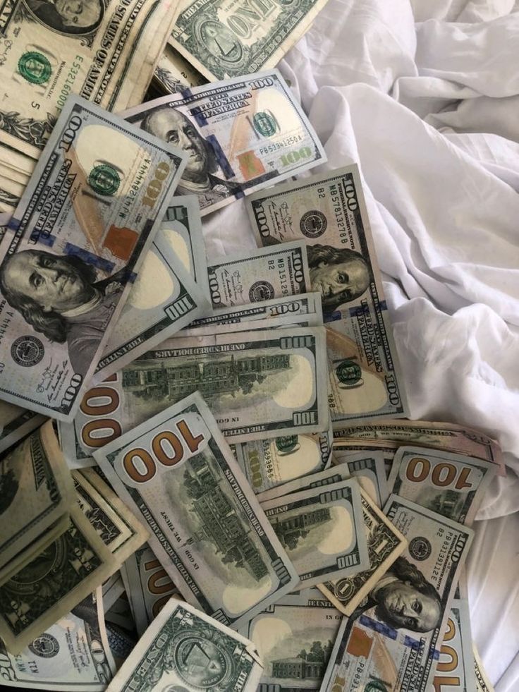 a pile of twenty dollar bills laying on top of a white sheet covered in sheets