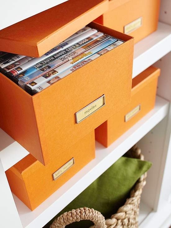 an orange shelf with magazines and other items on it's shelves, which are labeled to