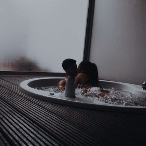 two people sitting in a bathtub with their backs to each other