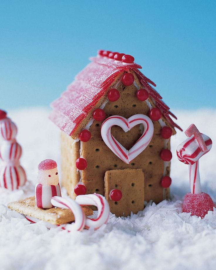 a gingerbread house is decorated with candy canes and candies in the snow