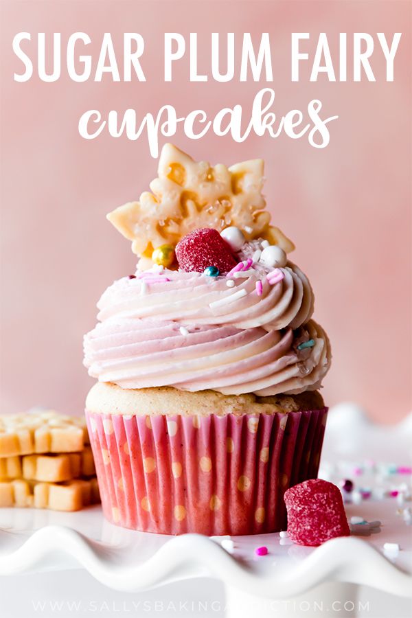 there is a cupcake with pink frosting and raspberries on top