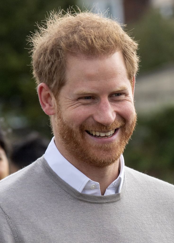 a close up of a person wearing a sweater and smiling