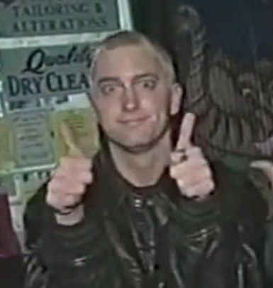 a man in black leather jacket giving the peace sign