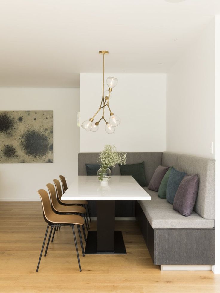 a dining room table with four chairs and a bench in front of it, next to a couch