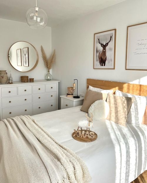 a bedroom with white furniture and pictures on the wall