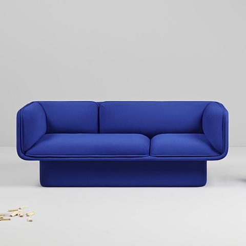 a blue couch sitting on top of a white floor next to a pile of gold coins